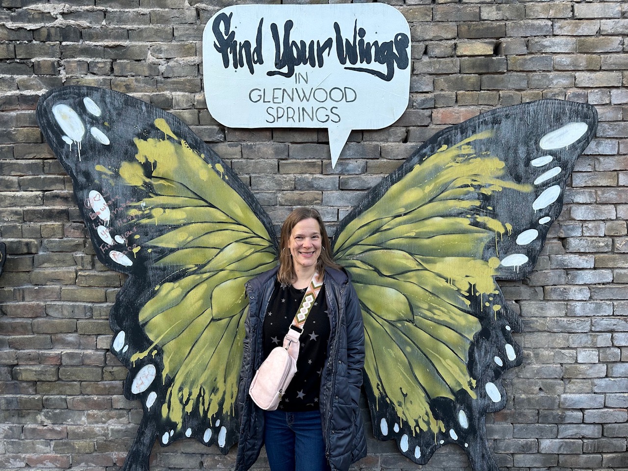 Photo of the author in front of butterfly wings